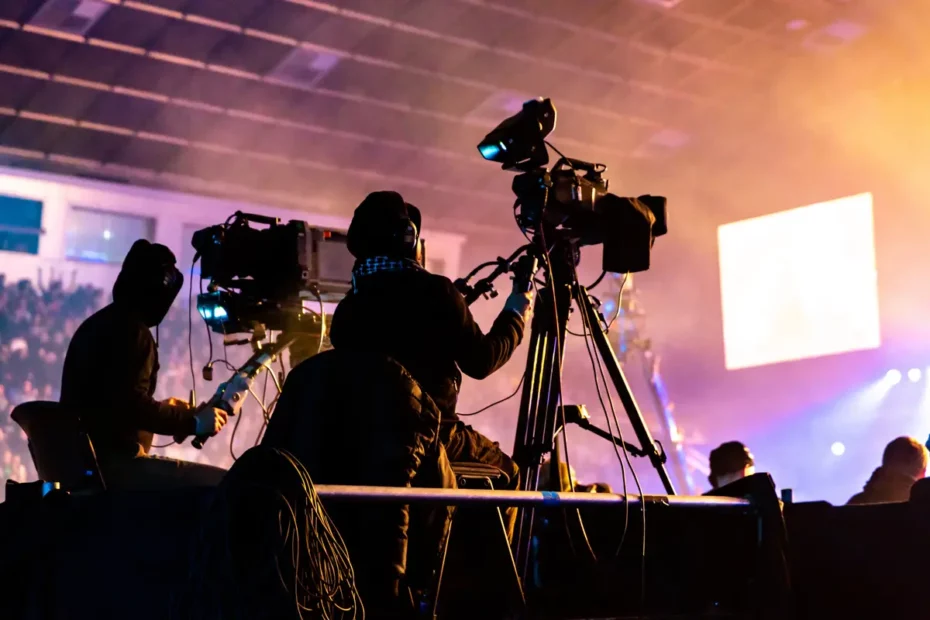 TV camera operators filming stage at indoor venue