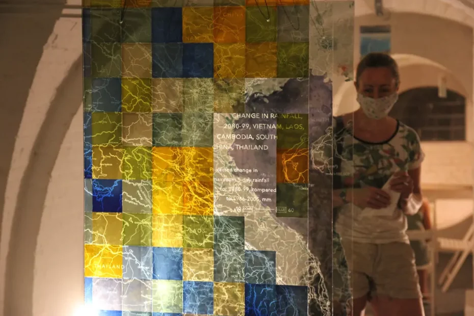 map of Cambodia on glass wall with person in face mask viewing it
