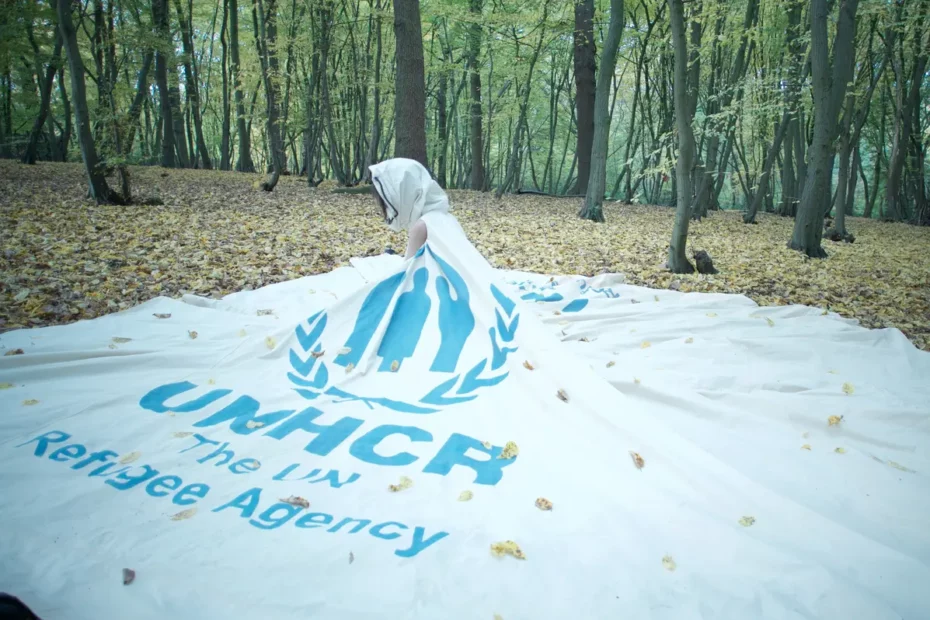 UNHCR banner laid on ground in woods