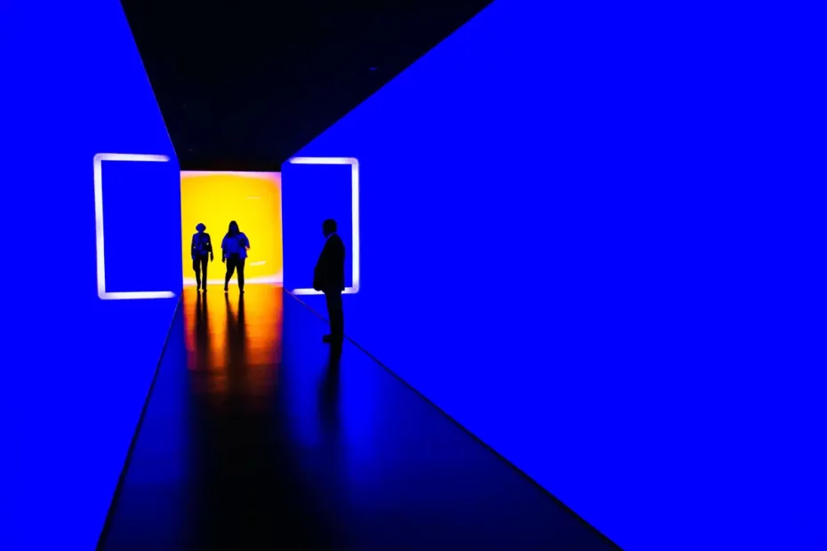 people in room in art gallery lit with blue light