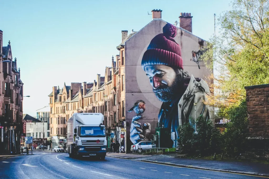 Side of building with artwork of man and a robin