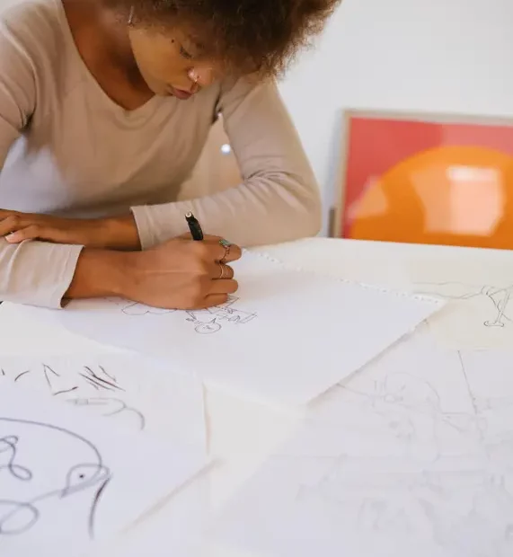 young person drawing on white paper