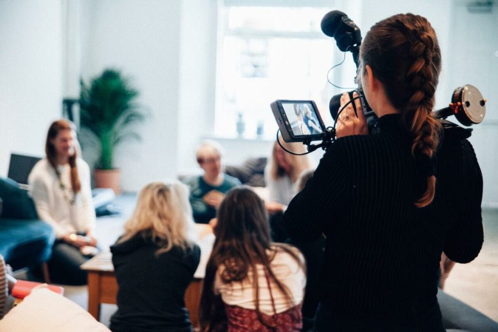 image of camera person filiming group in a room