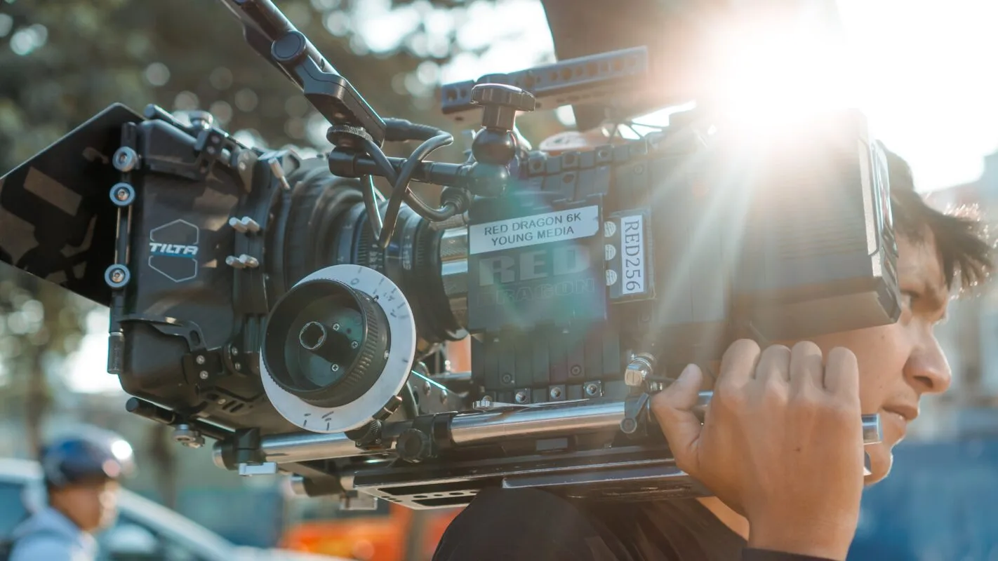 camera person carrying camera on shoulder