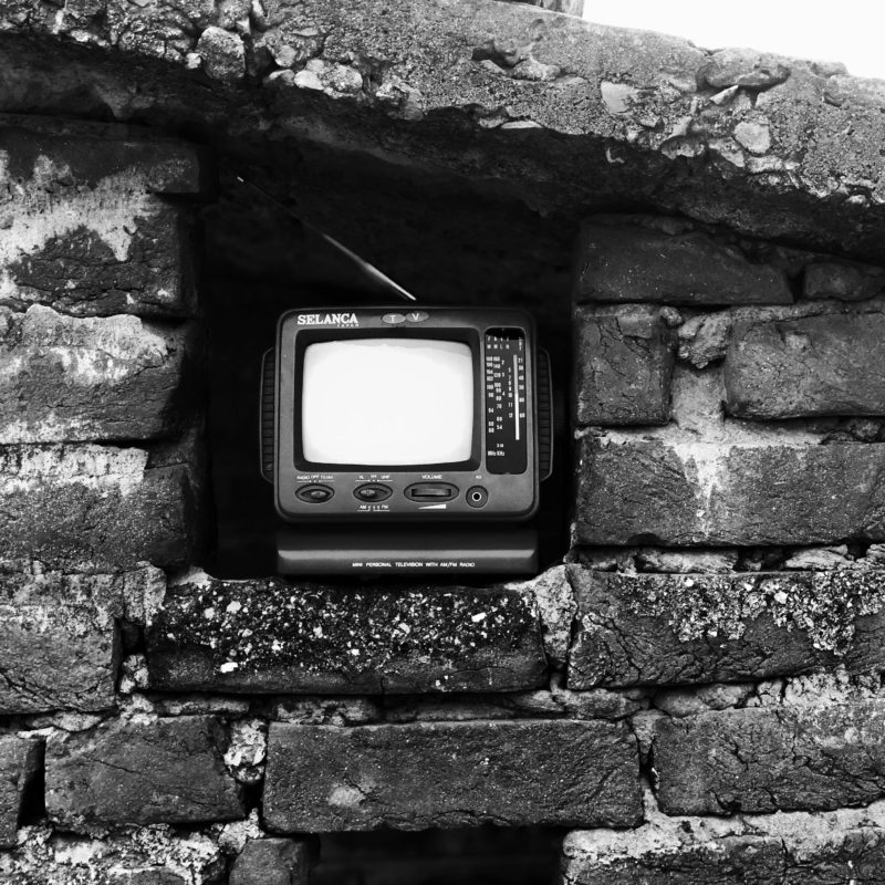 picture of old portable TV sat in gap in stone wall - courtesy of Shubham Verma