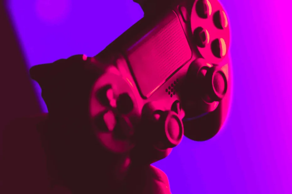 Image of video game controller under pink lighting with a purple background